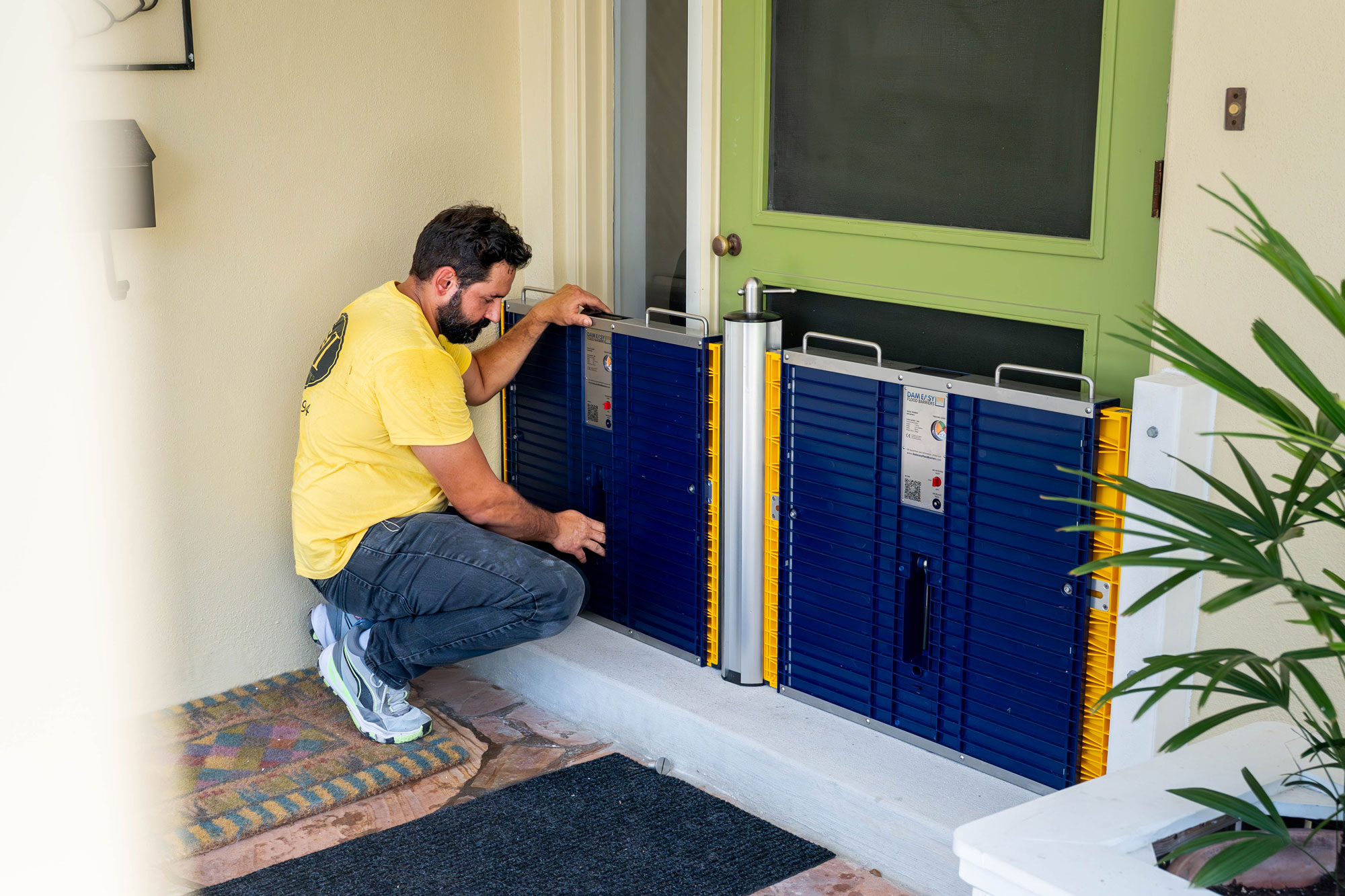 Dam Easy flood barriers being installed by a professional to protect a residential doorway from flooding.